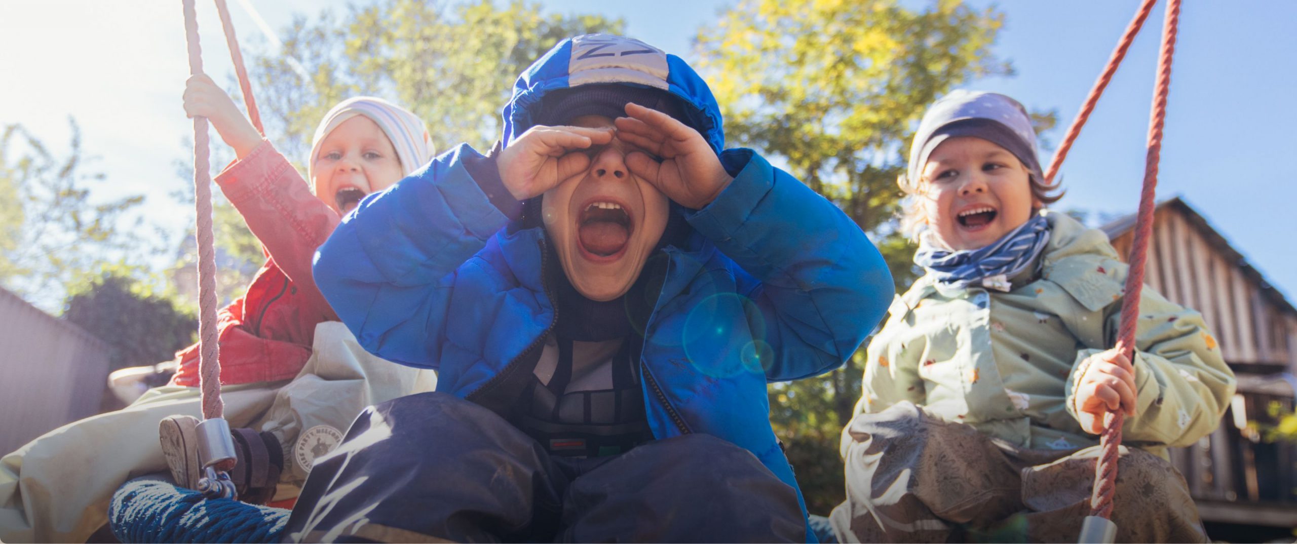 Drei Kinder auf einer Schaukel